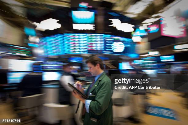 Trader works on the floor at the closing bell of the Dow Industrial Average at the New York Stock Exchange on November 8, 2017 in New York. Wall...