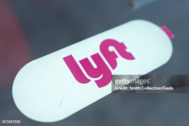 Close-up of logo for ride sharing and crowdsourced taxi service Lyft on a Lyft vehicle in the San Francisco Bay Area town of Daly City, California,...