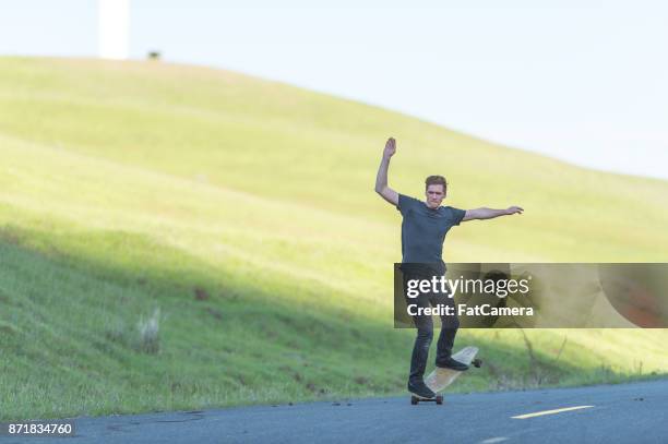 mid adult man longboards down rural highway - i pace concept car stock pictures, royalty-free photos & images