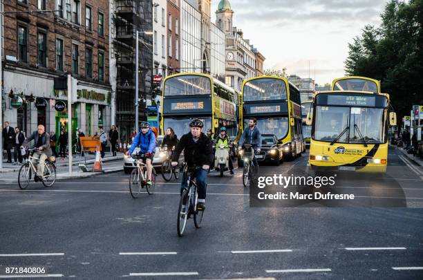 vista frontale delle persone in bicicletta nel centro di o'connell street di dublino in irlanda durante l'ora di punta al giorno d'autunno - dublin bus foto e immagini stock