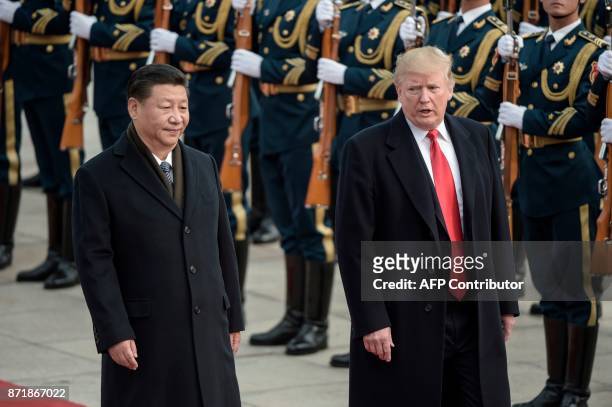 China's President Xi Jinping and US President Donald Trump review Chinese honour guards during a welcome ceremony at the Great Hall of the People in...