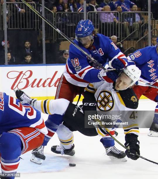 Marc Staal of the New York Rangers checks Danton Heinen of the Boston Bruins during the second period at Madison Square Garden on November 8, 2017 in...
