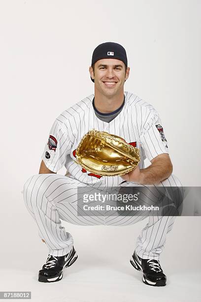 Joe Mauer of the Minnesota Twins poses with the 2008 Golden Glove Award he earned before the game against the Seattle Mariners on May 9, 2009 at the...