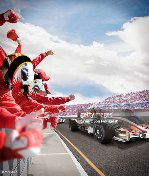 pit crew cheers for winning driver - fokus auf den hintergrund stock-fotos und bilder