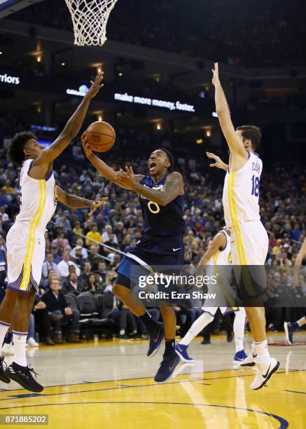 Jeff Teague of the Minnesota Timberwolves goes up for a shot against Nick Young and Omri Casspi of the Golden State Warriors at ORACLE Arena on...