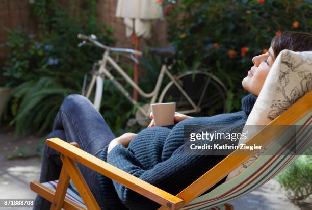 beautiful pregnant woman relaxing on deck chair with a cup of tea - femme enceinte jardin photos et images de collection