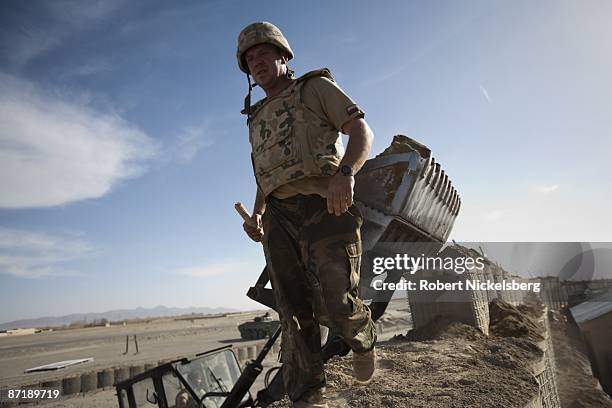 Polish Army soldier helps fill a Hesco barrier wall at an afghan observation post manned by units of the Afghan National Police, ANP, in Qarabagh,...