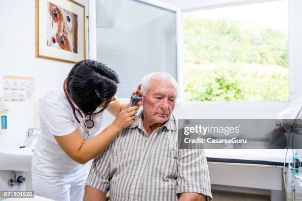 医療の耳チェック アップで年配の男性 - 耳の検査 ストックフォトと画像