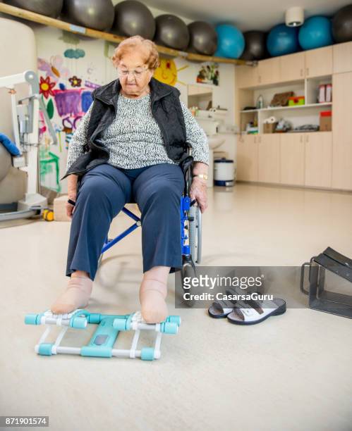 senior woman doing a physiotherapy exercise in retirement home - peloton tread stock pictures, royalty-free photos & images