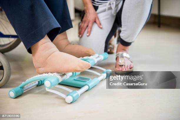 caregiver helping senior woman with phisyotherapy exercise - peloton tread stock pictures, royalty-free photos & images