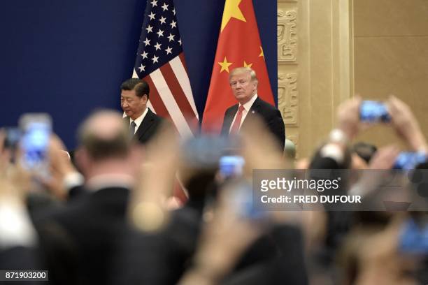 President Donald Trump and Chinese President Xi Jinping attend a business meeting at the Great Hall of the People in Beijing on November 9, 2017....