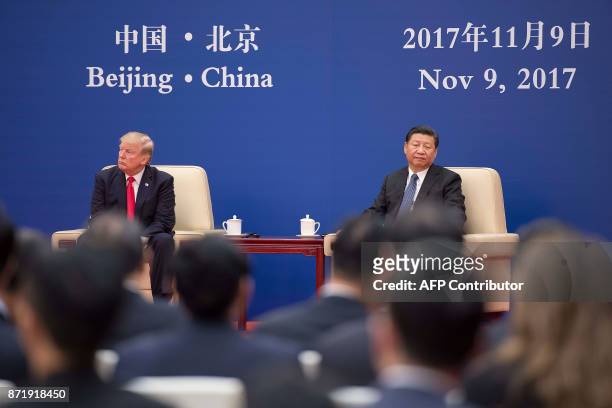 President Donald Trump and Chinese President Xi Jinping attend a business leaders meeting at the Great Hall of the People in Beijing on November 9,...