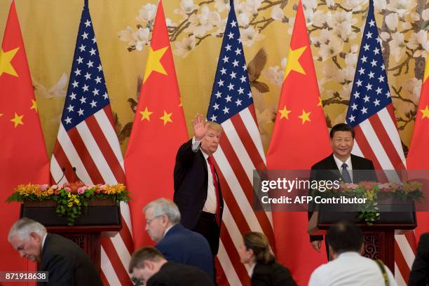 President Donald Trump waves next to Chinese President Xi Jinping after delivering a joint statement at the Great Hall of the People in Beijing on...