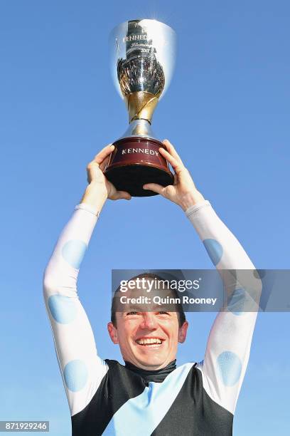 Stephen Baster who rode Pinot lifts up the cup after winning race 8, the Kennedy Oaks, on 2017 Oaks Day at Flemington Racecourse on November 9, 2017...