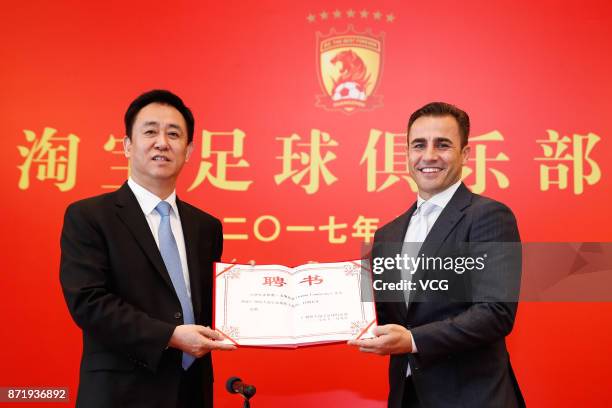 Chairman of Evergrande Group Xu Jiayin and new head coach of Guangzhou Evergrande Fabio Cannavaro pose for photos with the letter of appointment...