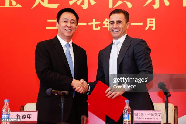 Chairman of Evergrande Group Xu Jiayin shakes hands with new head coach of Guangzhou Evergrande Fabio Cannavaro during a press conference on November...