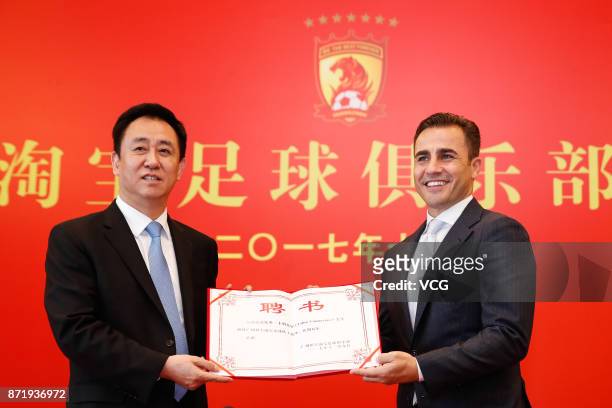 Chairman of Evergrande Group Xu Jiayin and new head coach of Guangzhou Evergrande Fabio Cannavaro pose for photos with the letter of appointment...
