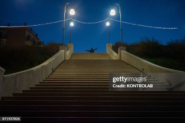 The statue of Domenico Modugno up to flight of steps, born in Polignano a Mare, in a village square in Puglia, southern Italy.