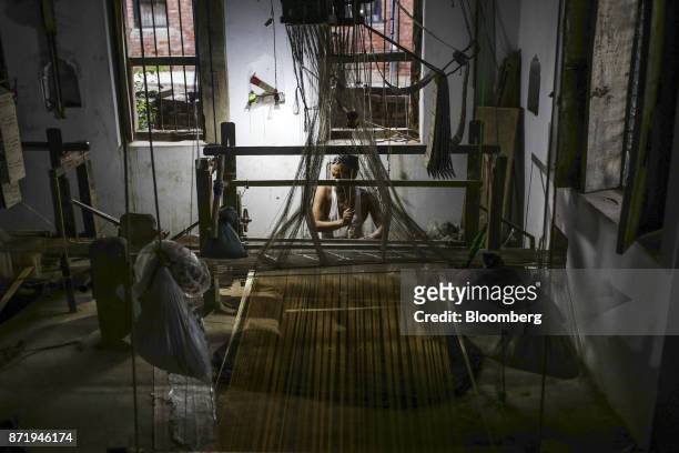 Weaver uses a handloom to make a silk saree in a workshop in Varanasi, Uttar Pradesh, India, on Friday, Oct. 27, 2017. In Varanasi, where the...