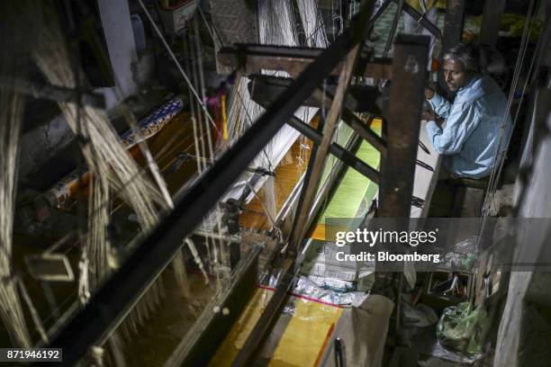 Weaver uses a handloom to make a silk saree in a workshop at night in Varanasi, Uttar Pradesh, India, on Saturday, Oct. 28, 2017. In Varanasi, where...