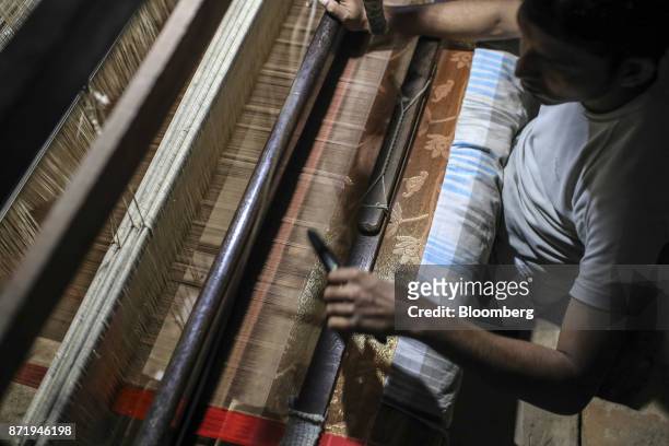 Weaver uses a shuttle on a handloom to make a silk saree in a workshop in Varanasi, Uttar Pradesh, India, on Friday, Oct. 27, 2017. In Varanasi,...