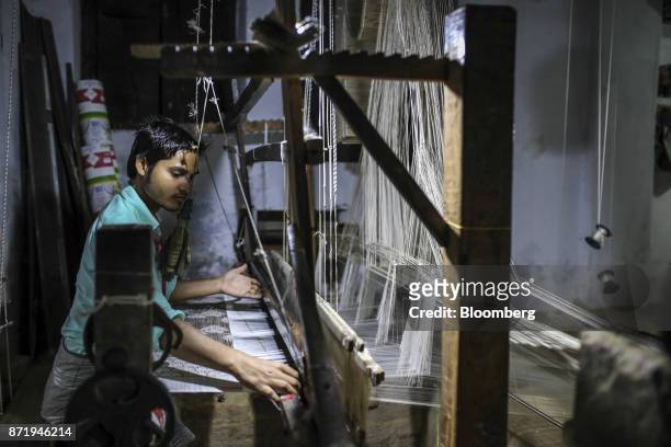 Weaver uses a handloom to make a silk saree in a workshop at night in Varanasi, Uttar Pradesh, India, on Friday, Oct. 27, 2017. In Varanasi, where...