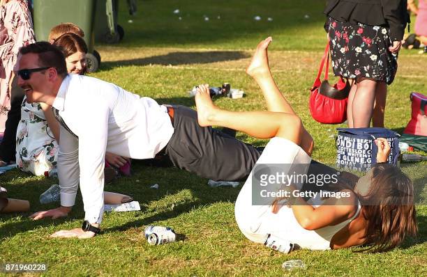 Racegoers fall to the ground as they make their way from the course following 2017 Oaks Day at Flemington Racecourse on November 9, 2017 in...