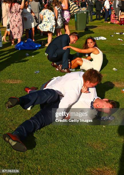 Racegoers fall to the ground as they make their way from the course following 2017 Oaks Day at Flemington Racecourse on November 9, 2017 in...