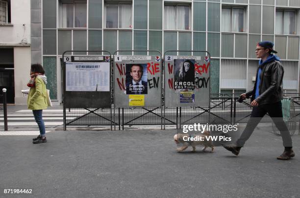 People walking by campaign posters of French presidential candidate Emmanuel Macron of the En Marche ! movement on the 18th district of Paris as...