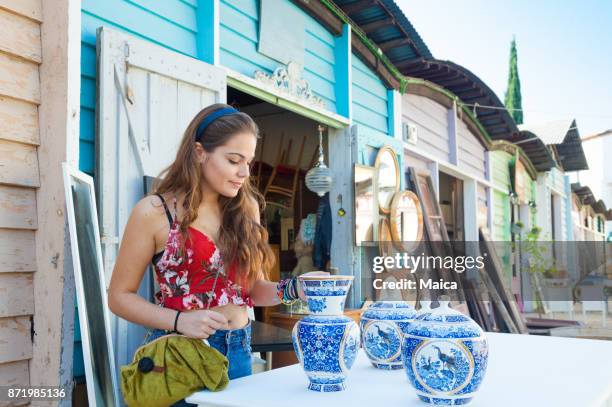 mujeres jóvenes comprar porcelana en el mercado - venta de garaje fotografías e imágenes de stock