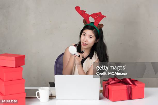 summer christmas,a young office lady sits at the work desk with some christmas presents - southern hemisphere fotografías e imágenes de stock