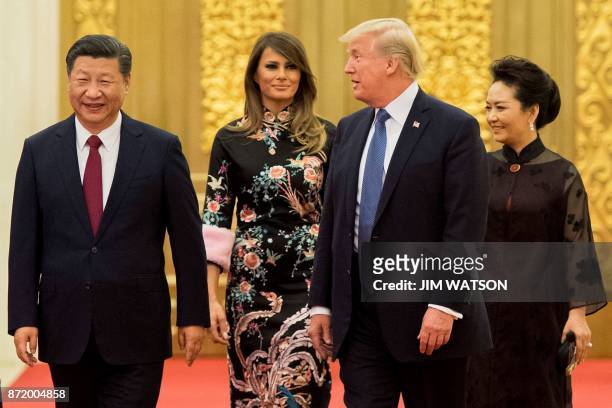 President Donald Trump speaks to China's President Xi Jinping , as US First Lady Melania Trump and Xi's wife Peng Liyuan look on, the Great Hall of...