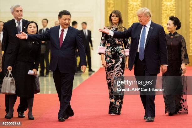 President Donald Trump gestures toward China's President Xi Jinping , as US First Lady Melania Trump and Xi's wife Peng Liyuan look on, the Great...