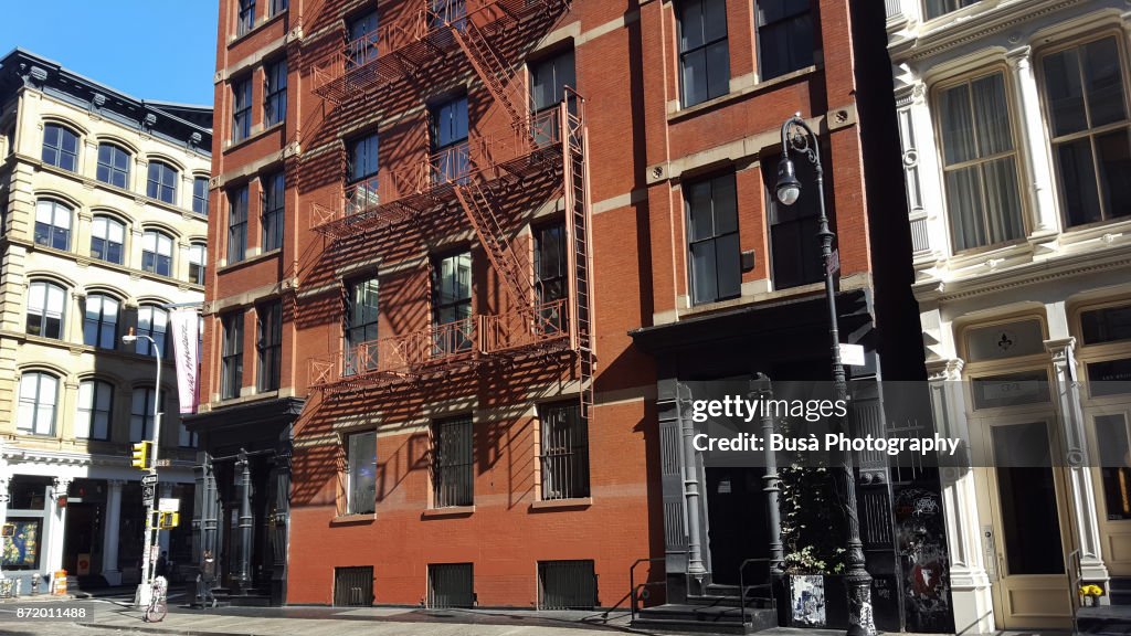Facades of typical cast iron buildings with fire escapes along Greene Street in the Soho Cast Iron Historic District, Manhattan, New York City