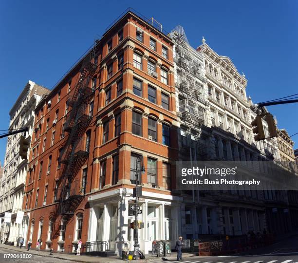 facades of typical cast iron buildings with fire escapes along greene street in the soho cast iron historic district, manhattan, new york city - soho new york 個照片及圖片檔