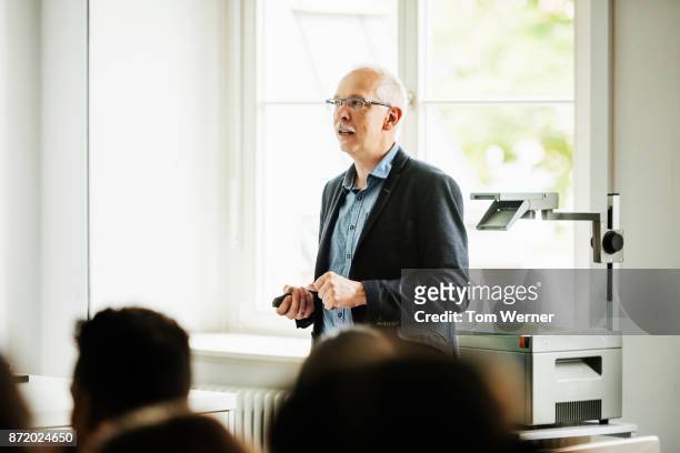 university tutor standing in front of class - professor stock-fotos und bilder