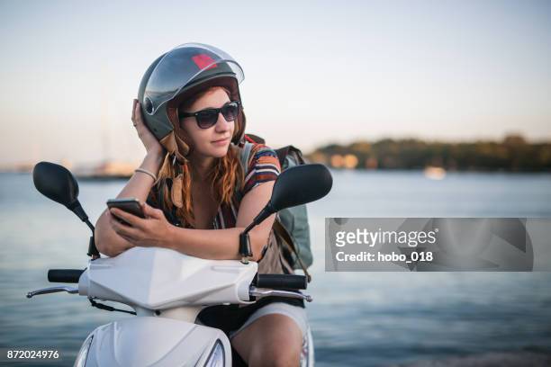 giovane donna grintosa in motorino - mare moto foto e immagini stock