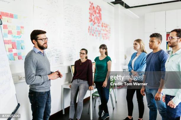 group of university students listening to tutor during seminar - professor stock-fotos und bilder