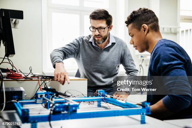 university tutor assisting student with technical problem - stem stock pictures, royalty-free photos & images
