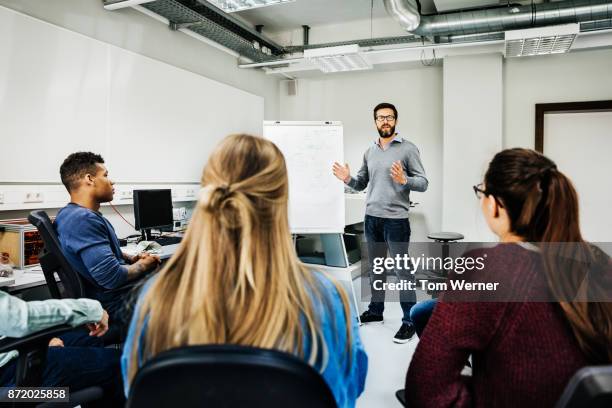 engineering tutor explaining concept during university seminar - teaching adults stockfoto's en -beelden
