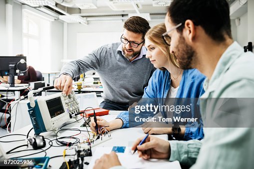 A Tutor Using Technology University Tutor Showing Students How To Use Electronic Equipment High ...