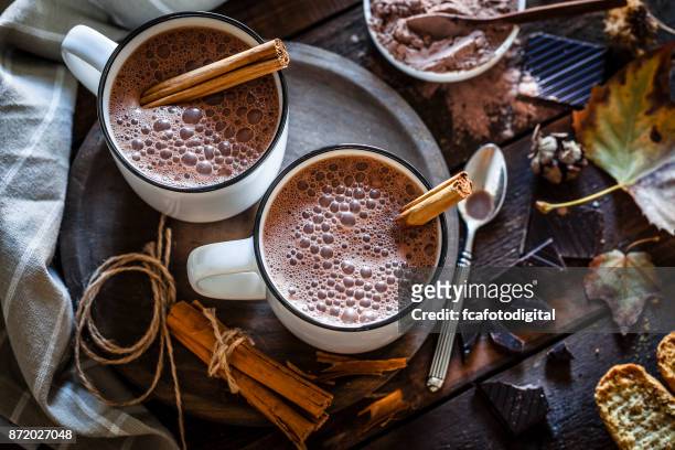 zwei hausgemachte heiße schokolade becher auf rustikalen holztisch - warm colours stock-fotos und bilder