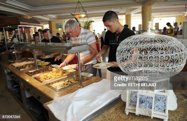 Tunisians and tourists serve themselves from a buffet at the Sidi Mansour restaurant in Djerba on August 1, 2010. AFP PHOTO / FETHI BELAID