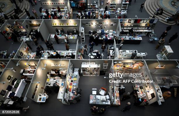 This general view shows exhibitors and visitors as they attend 'Paris Photo' at The Grand Palais in Paris on November 9, 2017. / AFP PHOTO / Lionel...