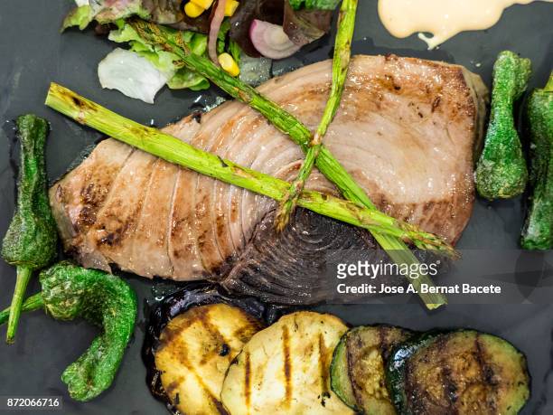 grilled fished tuna served on a plate of slate with  roast vegetables, peppers, asparagus and aubergine. - griddle stock pictures, royalty-free photos & images