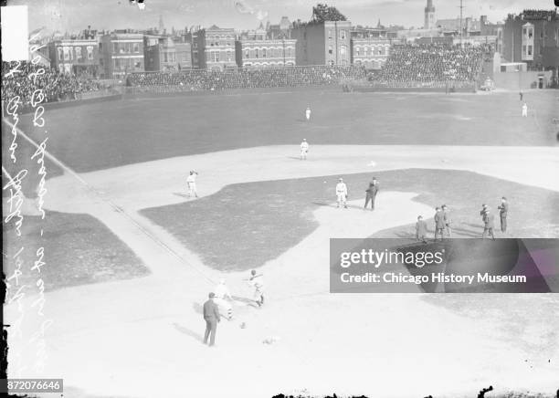 Photographers on the field capture the moment as retired baseball player Adrian 'Cap' Anson throws the first pitch of the Chicago Cubs' home opener...