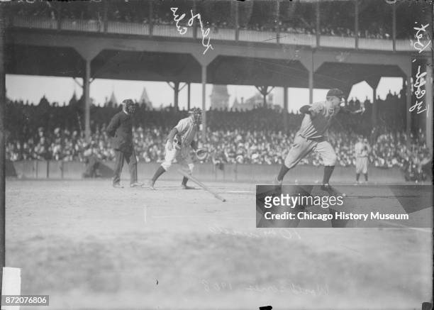 Baseball player Ty Cobb , of the Detroit Tigers, runs towards first base as Johnny Kling , catcher for the Chicago Cubs, watches during a World...