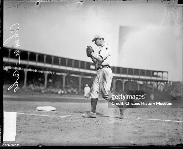 Baseball player Frank Chance , of the Chicago Cubs, walks behind first base on the field at West Side Grounds, Chicago, Illinois, 1908.