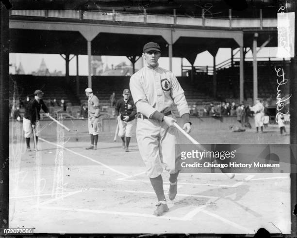 Baseball player Frank Schulte , of the Chicago Cubs, holds a bat near home plate on the field at West Side Grounds, Chicago, Illinois, 1909.