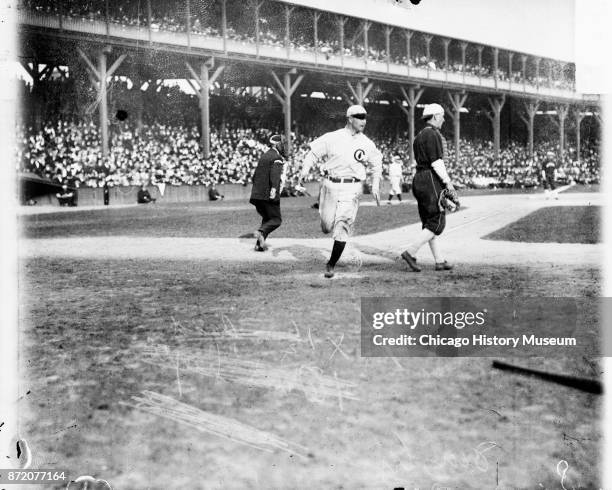 Baseball player Frank Chance , of the Chicago Cubs, crosses home plate during a game against the Chicago White Sox at West Side Grounds, Chicago,...